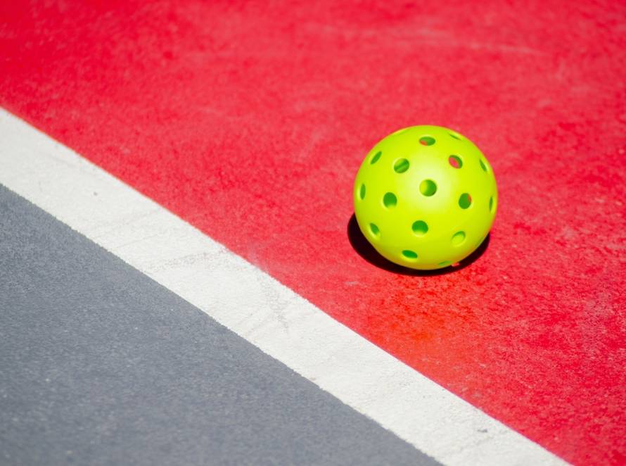 Pickleball liegt auf rotem Spielfeld